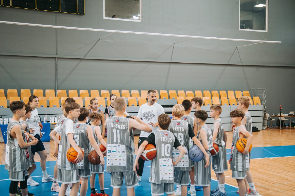 Players in a huddle with a coach at Global Hoops Camp